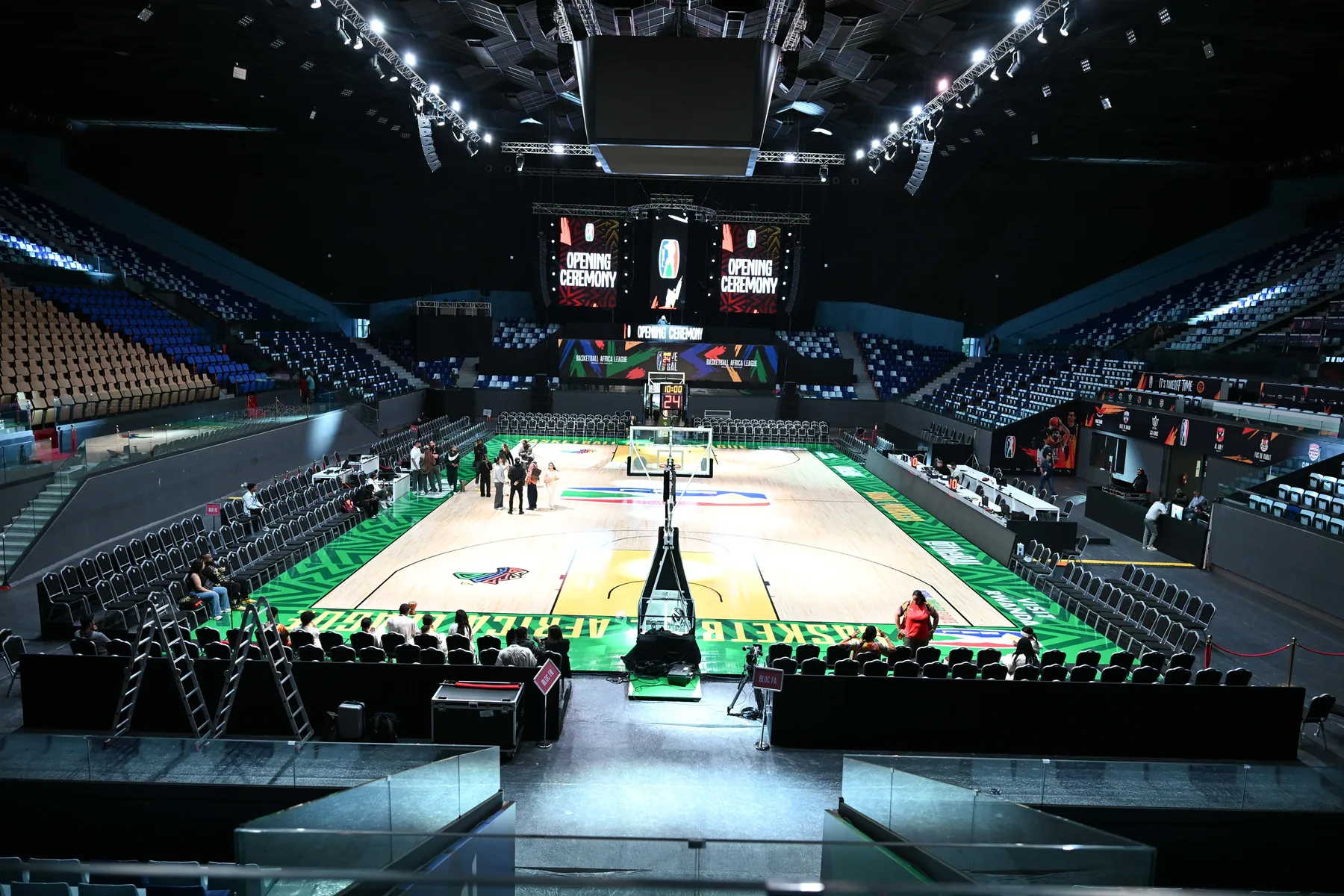 Installation technique dans une grande salle sportive avec terrain éclairé.