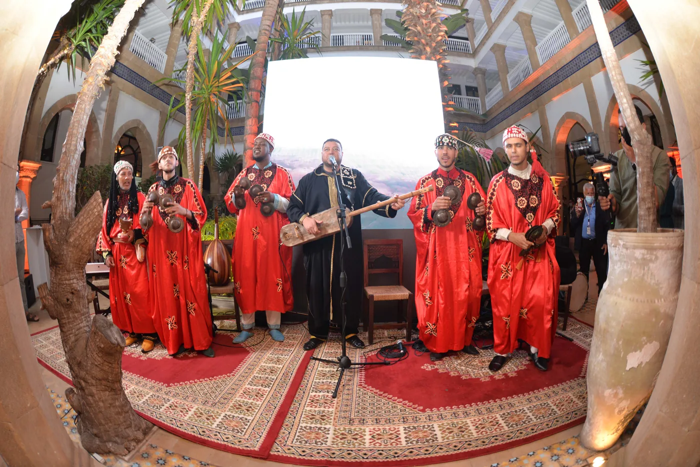 Accueil de réception avec musiciens traditionnels dans une cour intérieure.